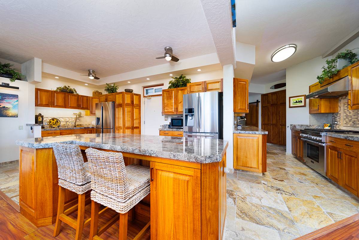 a kitchen with stainless steel appliances kitchen island granite countertop a refrigerator and microwave