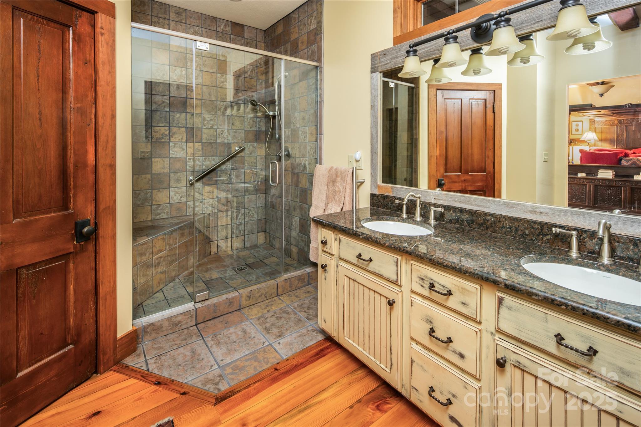 69 Dogwood Branch Road Zirconia, NC 28790 - Photo 27 of 48 a bathroom with a granite countertop sink a mirror and shower