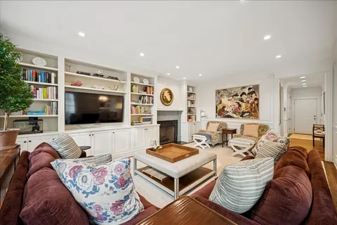 a living room with furniture kitchen and a flat screen tv
