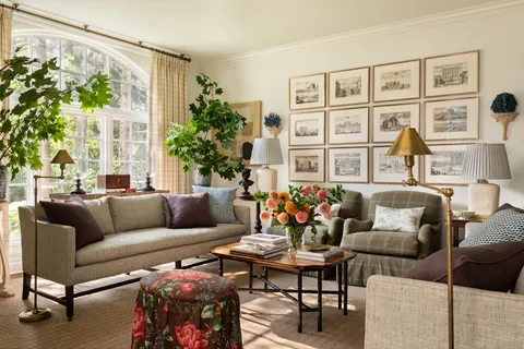 a living room with furniture and a large window with garden view