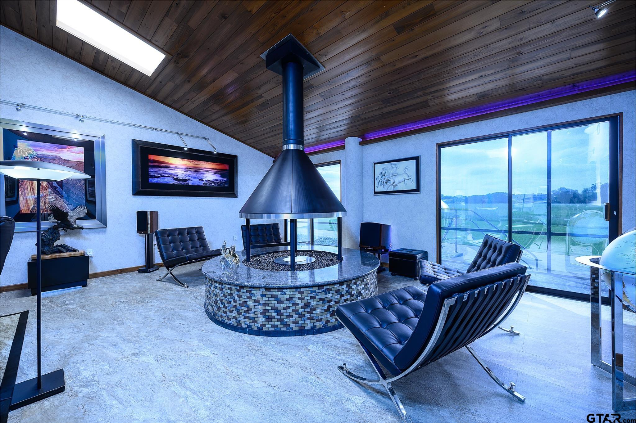 1085 County Road 1960 Yantis, TX 75497 - Photo 18 of 41 a living room with furniture a flat screen tv and floor to ceiling window