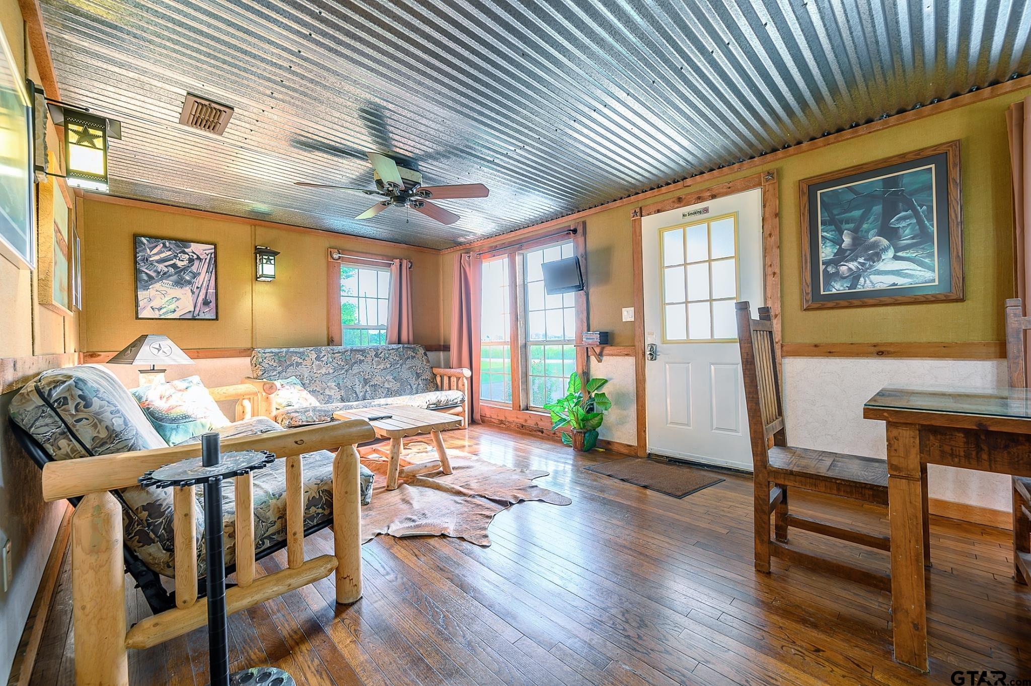 1085 County Road 1960 Yantis, TX 75497 - Photo 33 of 41 a living room with furniture a dining table wooden floor and a chandelier
