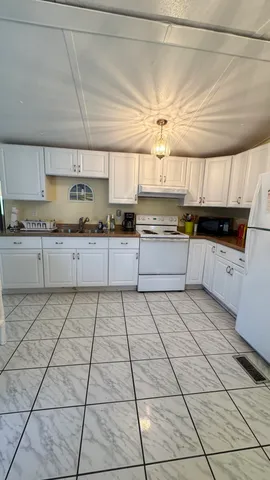 a kitchen with stainless steel appliances granite countertop a sink a stove and cabinets