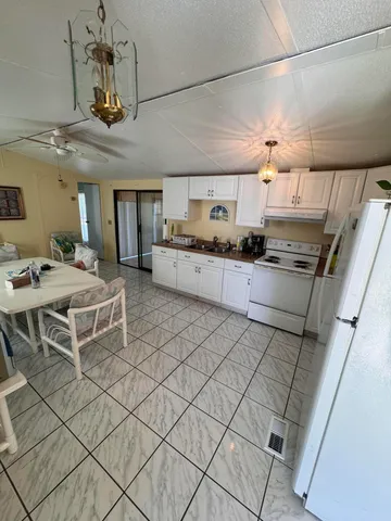 a kitchen with stainless steel appliances granite countertop a sink dishwasher a stove a dining table and chairs with wooden floor