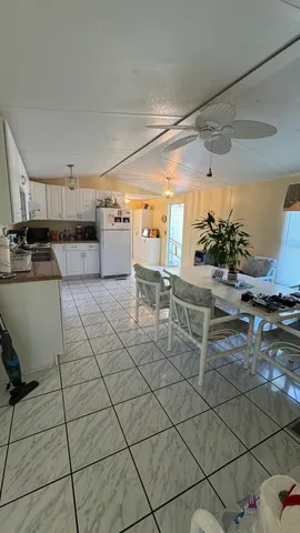 a kitchen with stainless steel appliances kitchen island granite countertop a rug and white cabinets