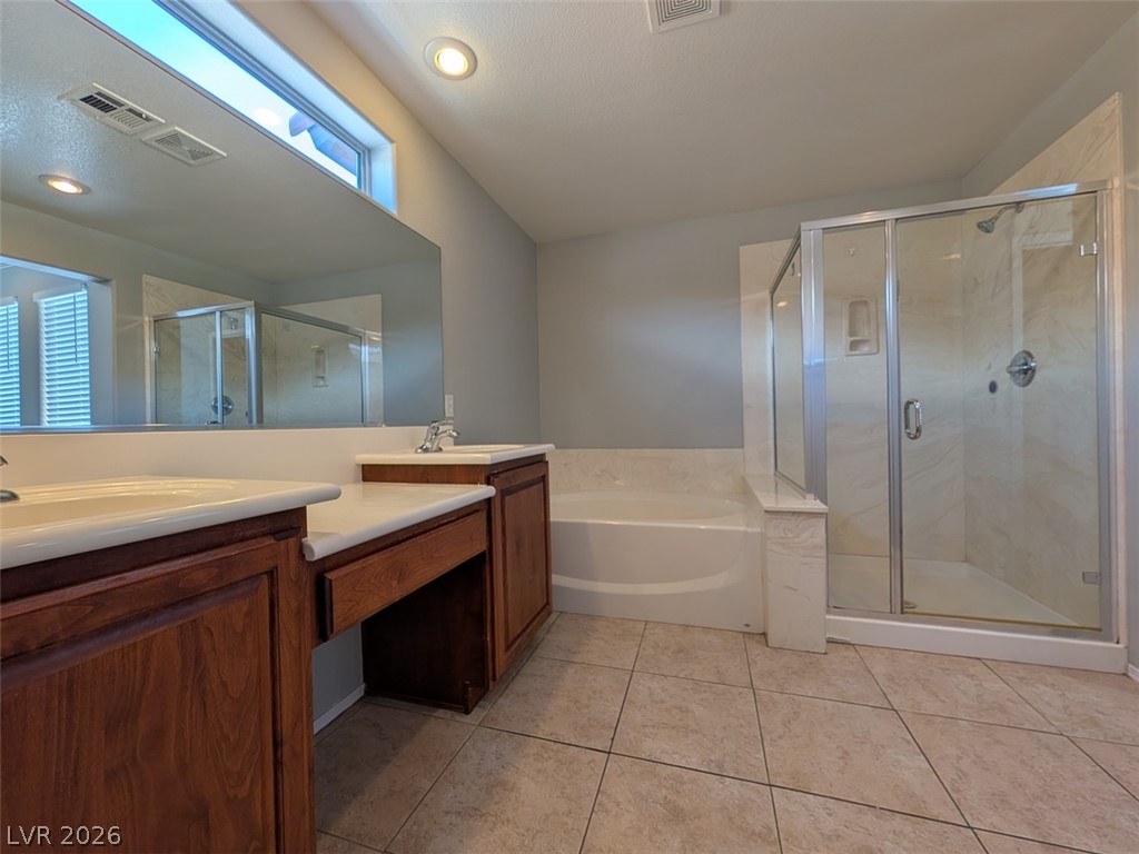 10308 Faustine Avenue Las Vegas, NV 89129 - Photo 13 of 28 A generously sized bathroom with a dual-sink vanity and separate shower and tub.