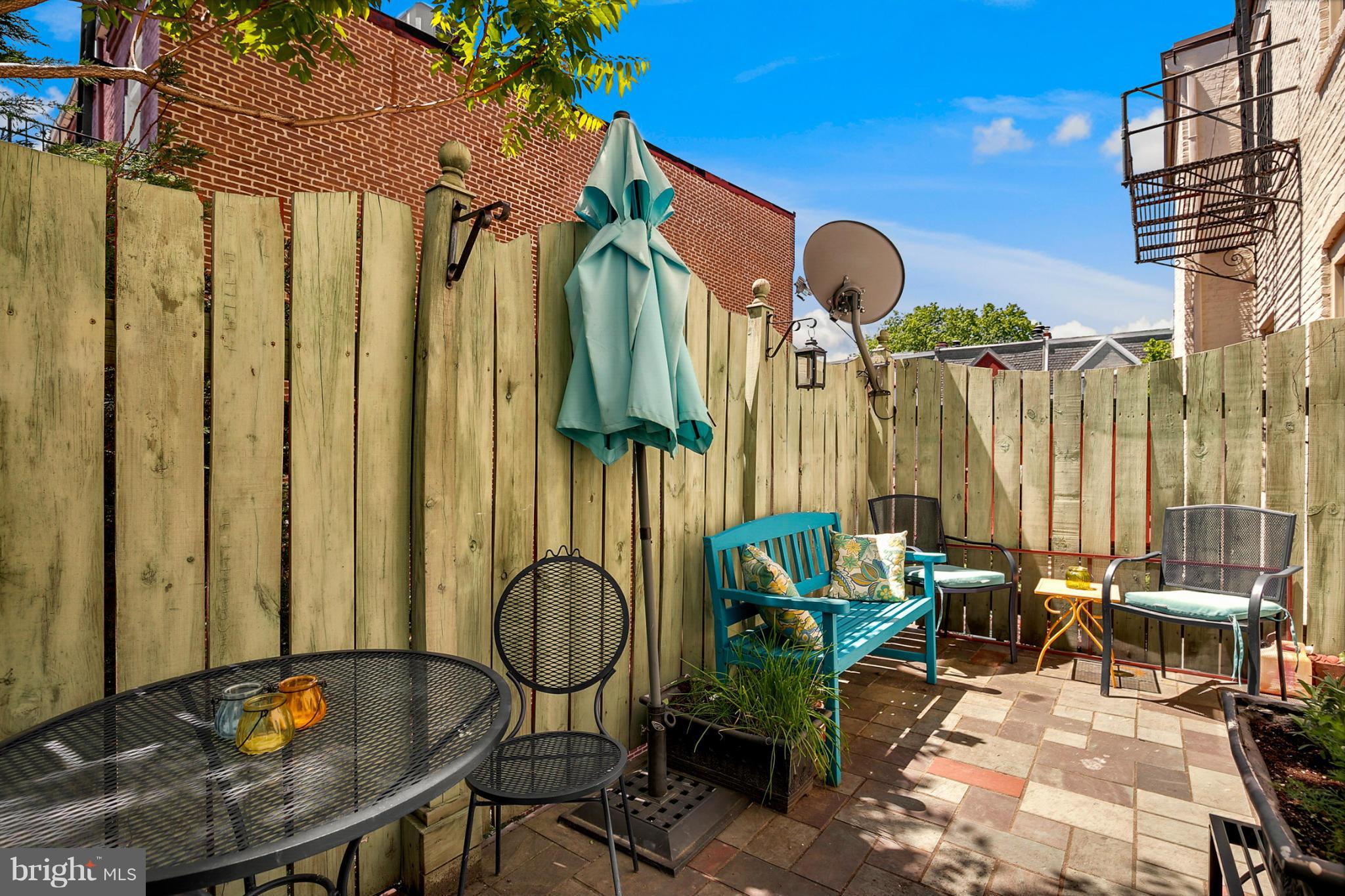 1454 Euclid Street Northwest, Unit 7 Washington, DC 20009 - Photo 23 of 23 a backyard of a house with barbeque oven table and chairs