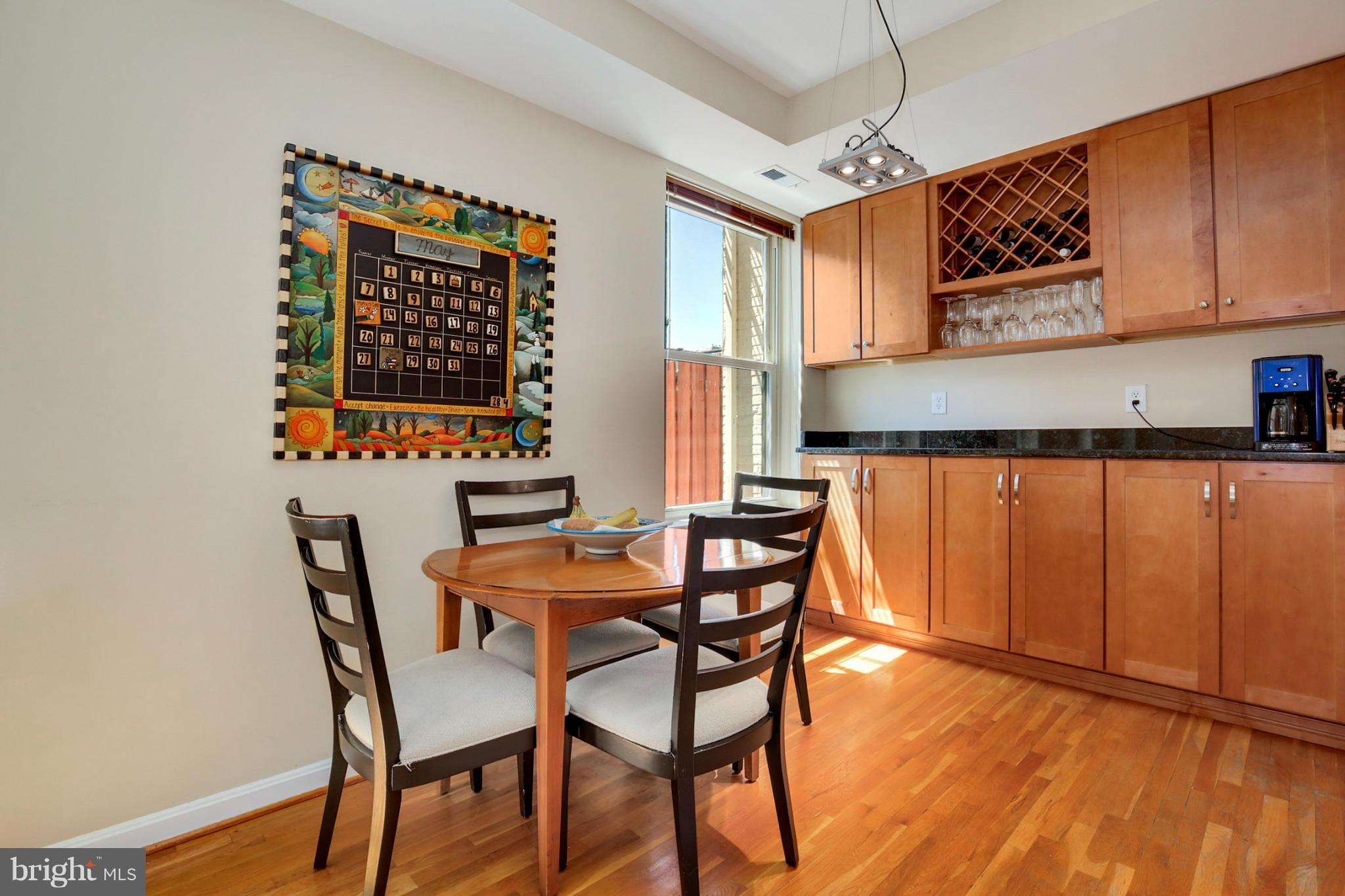 1454 Euclid Street Northwest, Unit 7 Washington, DC 20009 - Photo 6 of 23 a dining room with stainless steel appliances a wooden table and chairs