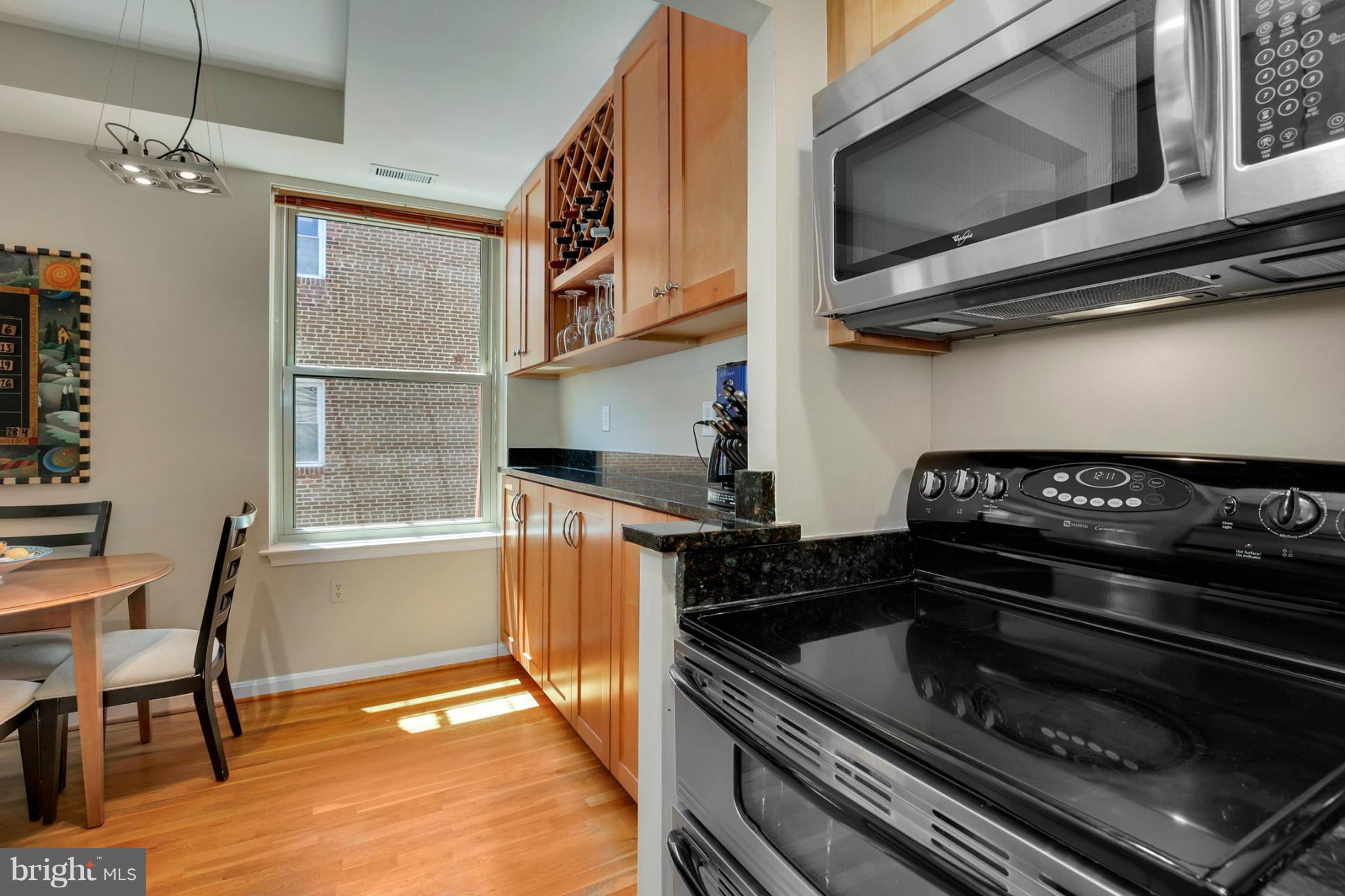 1454 Euclid Street Northwest, Unit 7 Washington, DC 20009 - Photo 9 of 23 a kitchen with wooden cabinets and a stove top oven