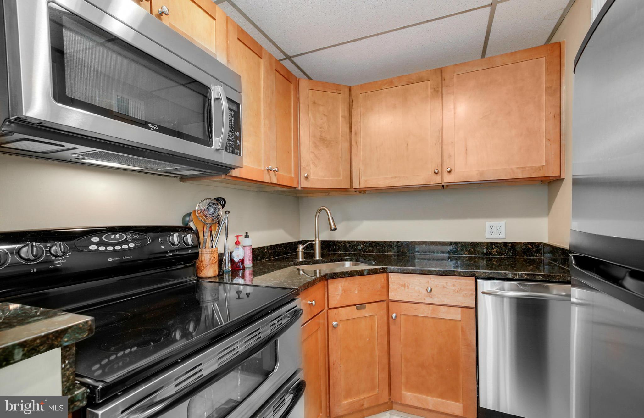 1454 Euclid Street Northwest, Unit 7 Washington, DC 20009 - Photo 10 of 23 a kitchen with stainless steel appliances granite countertop a stove and cabinets