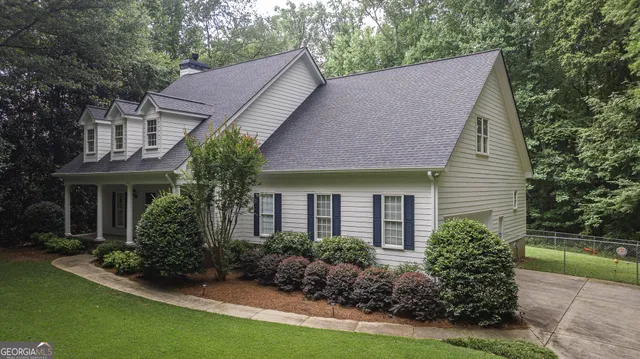 a view of house with garden and a tree