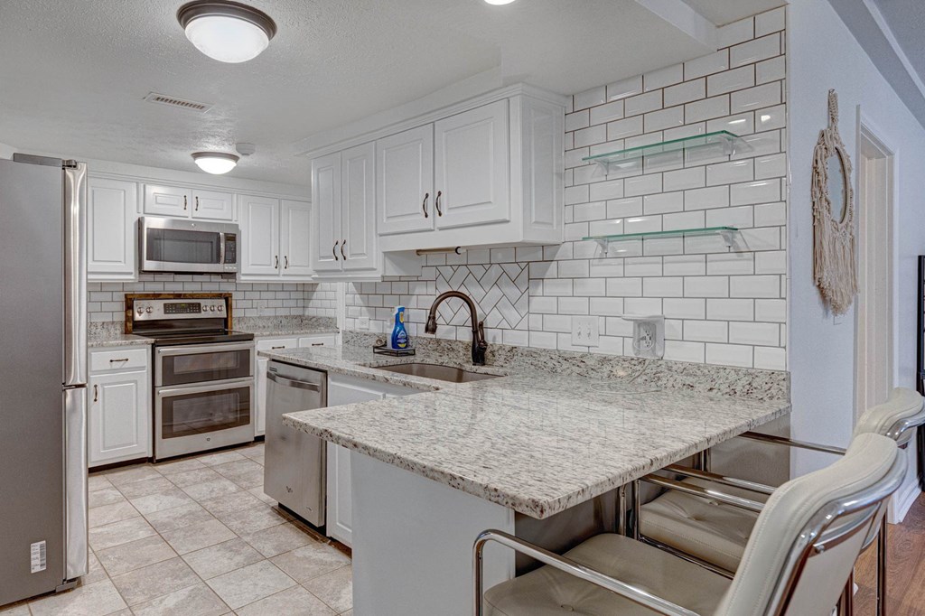 6101 River Road, Unit 5 Columbus, GA 31904 - Photo 14 of 47 a kitchen with stainless steel appliances granite countertop a sink dishwasher a stove top oven a refrigerator and dishwasher