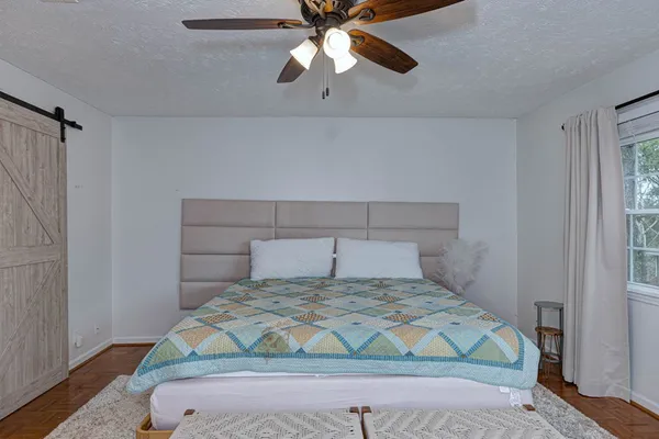 a bedroom with a bed and a ceiling fan