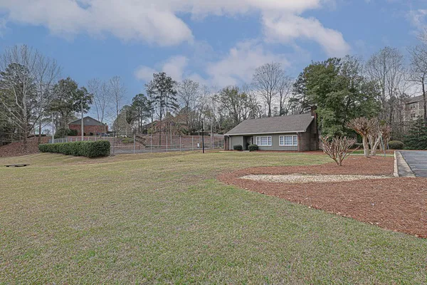 a front view of a house with a yard and trees