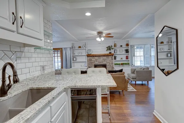 a kitchen with stainless steel appliances granite countertop a kitchen island a stove and a sink