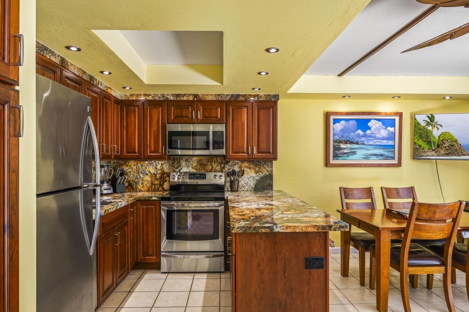 2495 South Kihei Road, Unit 171 Kihei, HI 96753 - Photo 2 of 18 a kitchen with stainless steel appliances granite countertop a refrigerator and a stove top oven