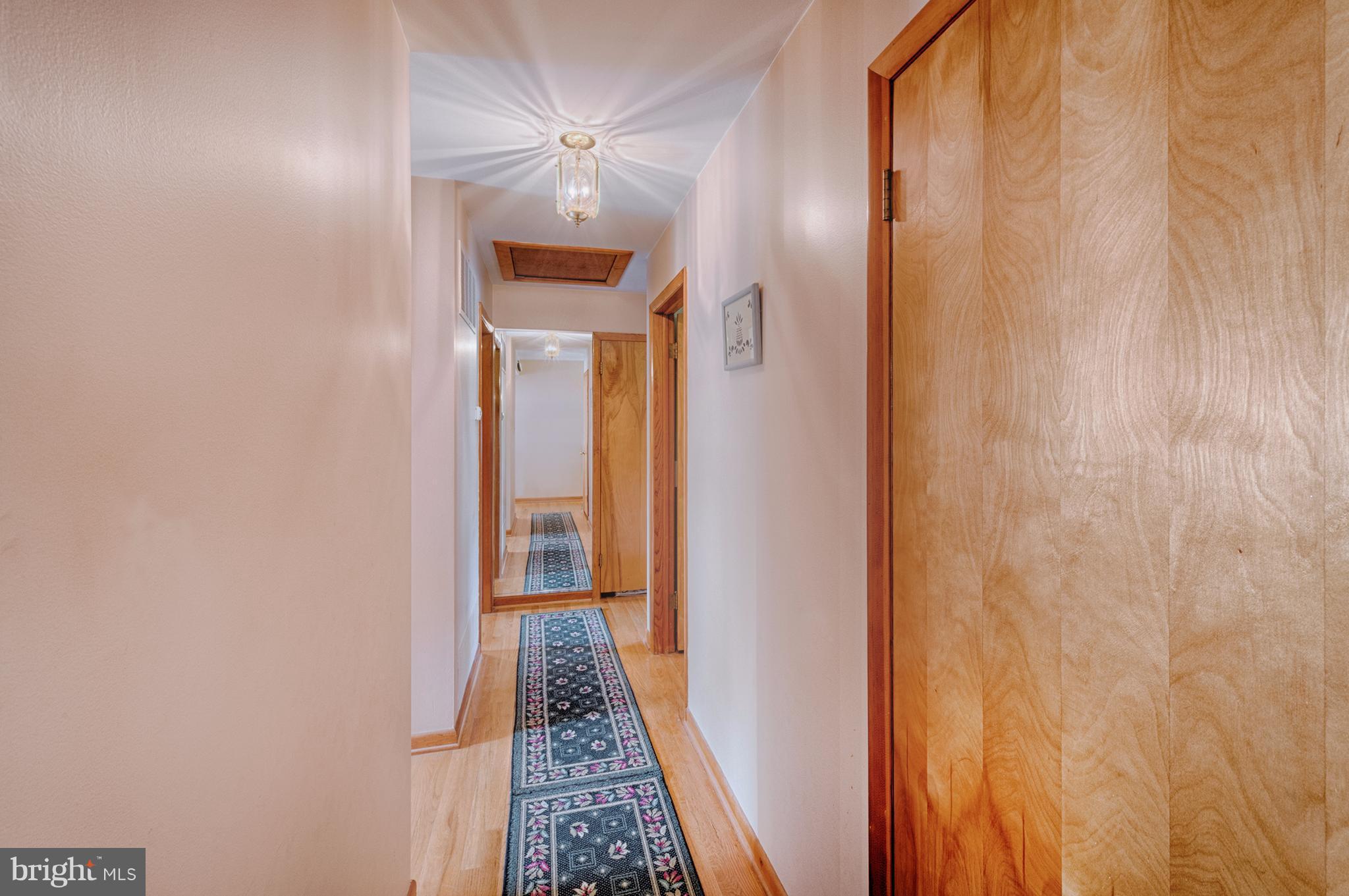 9501 Dawnvale Road Baltimore, MD 21236 - Photo 13 of 30 a view of a hallway with wooden floor and a bathroom