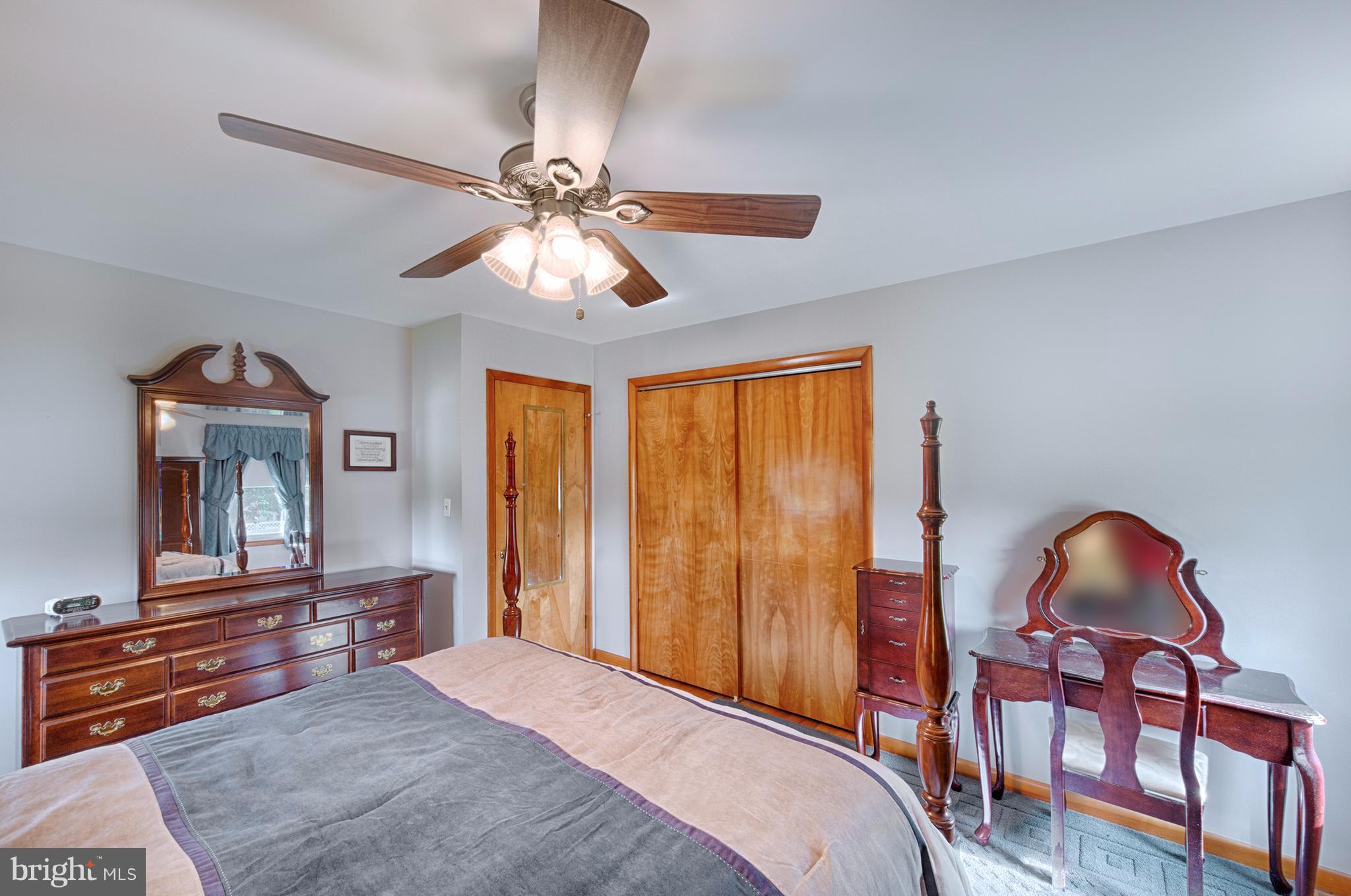9501 Dawnvale Road Baltimore, MD 21236 - Photo 20 of 30 a bedroom with a bed and a chandelier with a flat tv screen