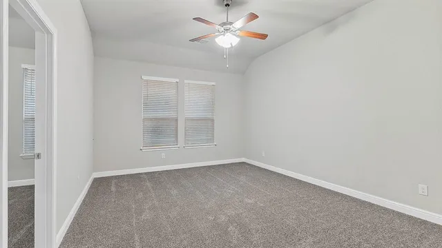 an empty room with a window and a fan