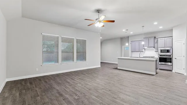 a view of kitchen with cabinets microwave and stove