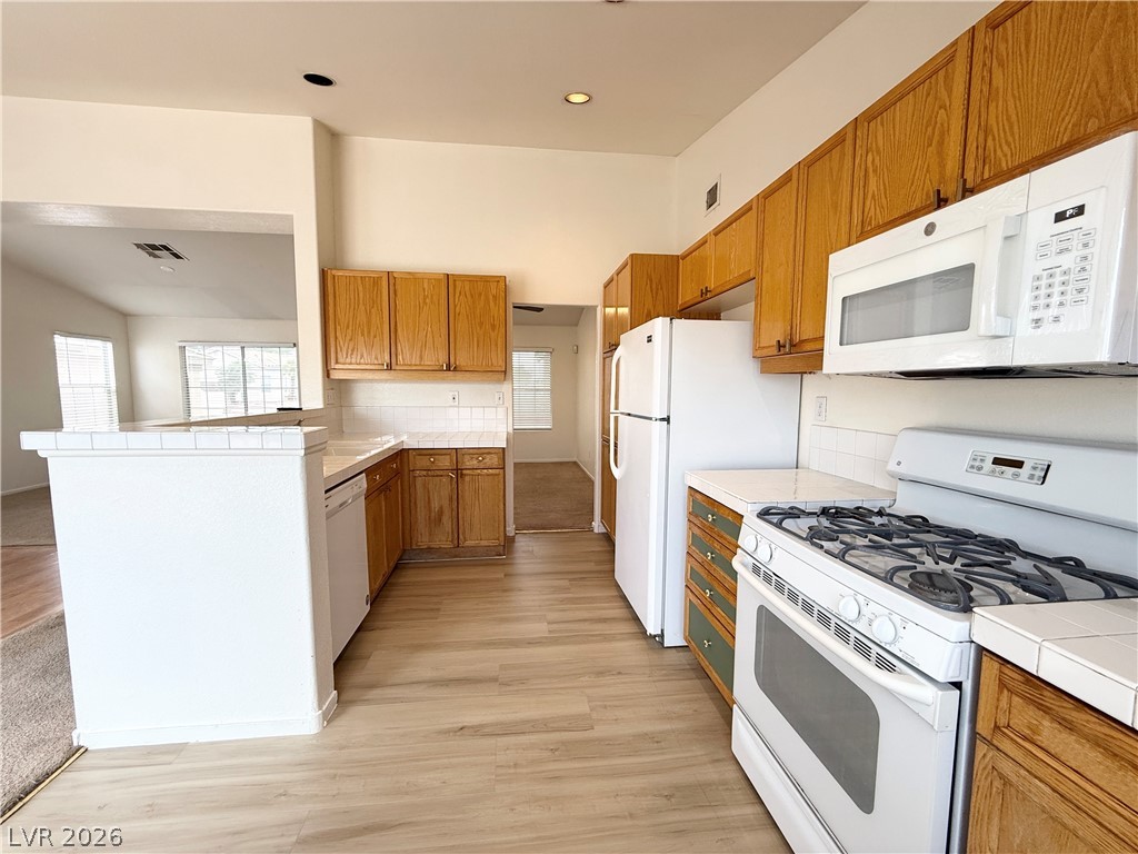 8870 Haviland Road Las Vegas, NV 89123 - Photo 8 of 24 A functional kitchen with light wood cabinetry and essential appliances awaits culinary endeavors.