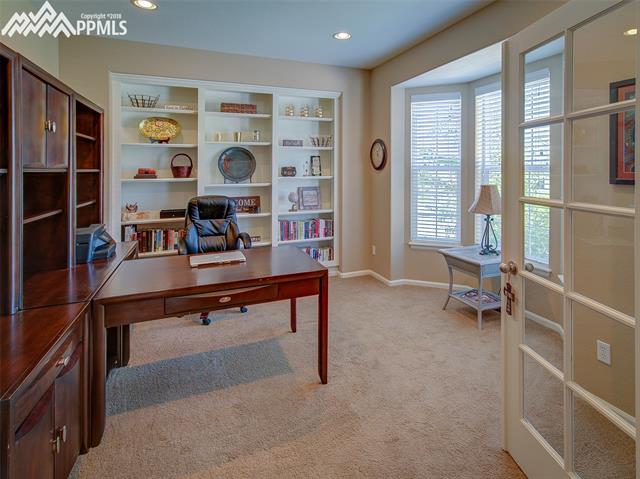 829 Spectrum Loop Colorado Springs, CO 80921 - Photo 2 of 19 Office space or sitting area just inside the front door and to the right with double french doors, bay window and built-in bookcases.
