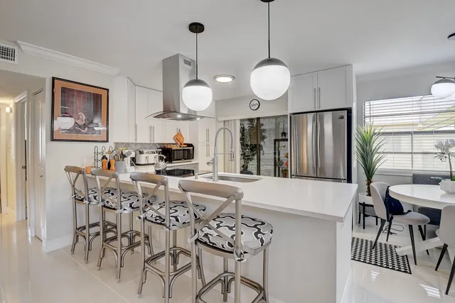 a kitchen with a sink a refrigerator and cabinets