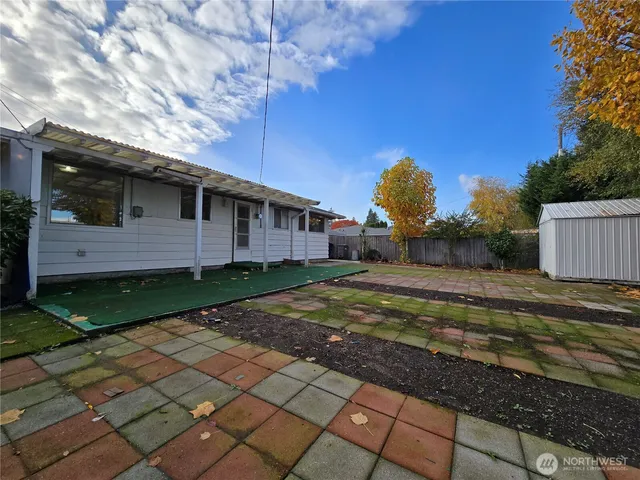 a view of a house with backyard and a tree