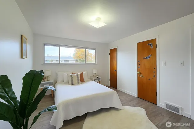 a bedroom with a bed and a potted plant