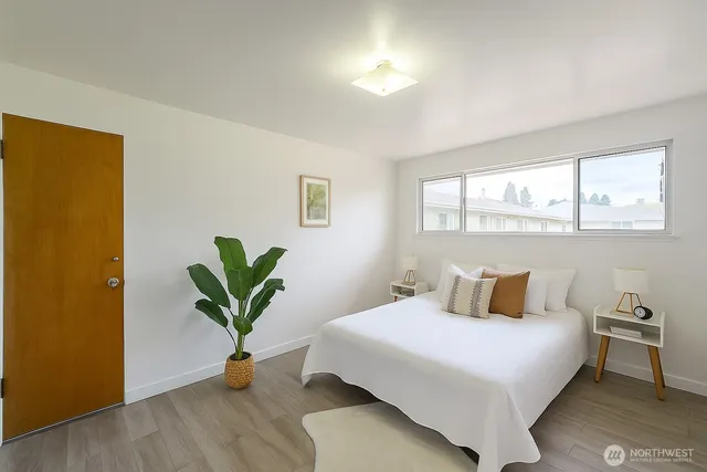 a bedroom with a large bed and a potted plant