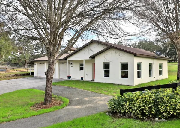 a front view of a house with a garden and garage