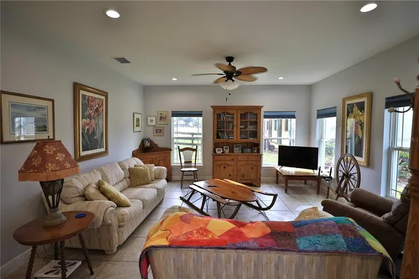 a living room with furniture kitchen view and a chandelier