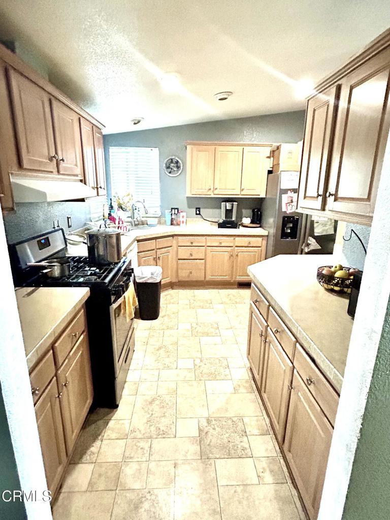 2400 East Pleasant Valley Road, Unit 108 Oxnard, CA 93033 - Photo 7 of 19 a kitchen with a sink a stove top oven and white cabinets