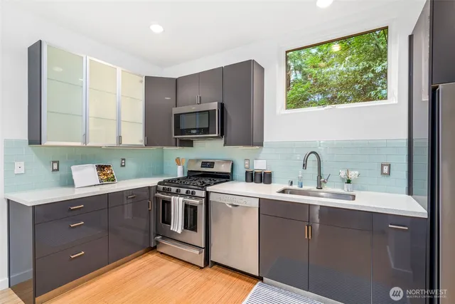 a kitchen with stainless steel appliances a stove microwave and sink