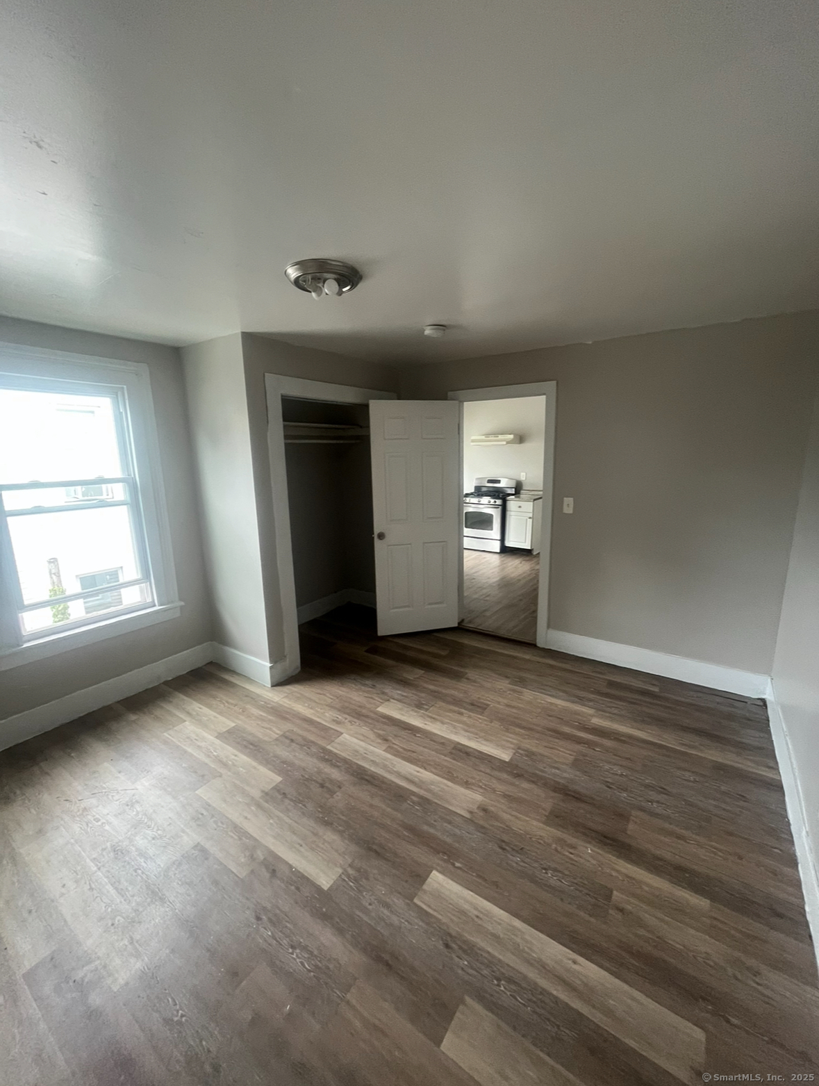 an empty room with windows and closet