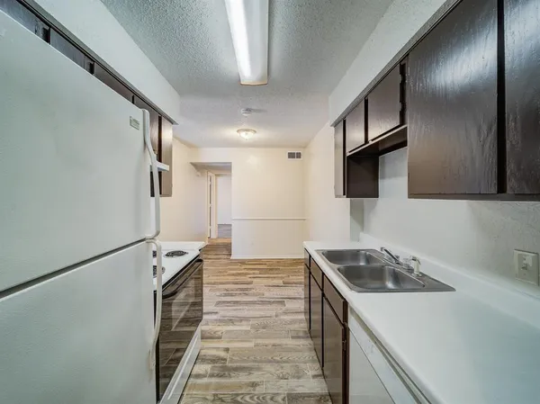 a kitchen with a sink stove and refrigerator