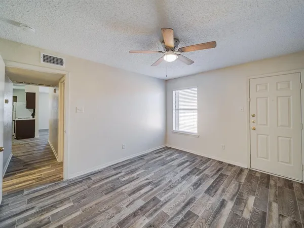 an empty room with closet and a ceiling fan