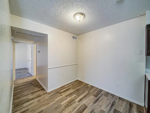 a view of a room with wooden floor and hallway