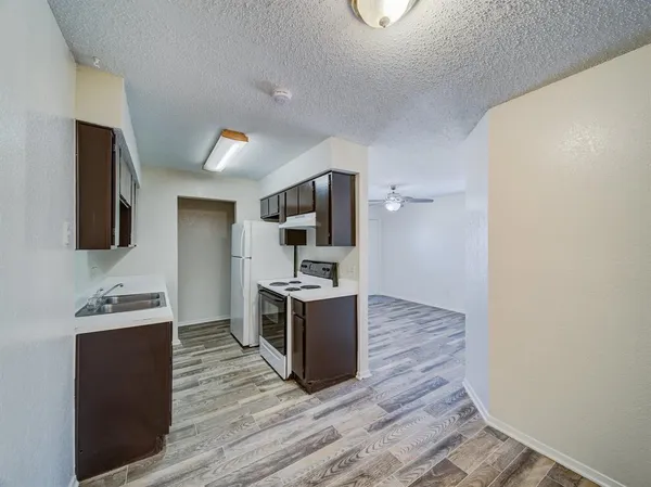 a kitchen with wooden floors and cabinets