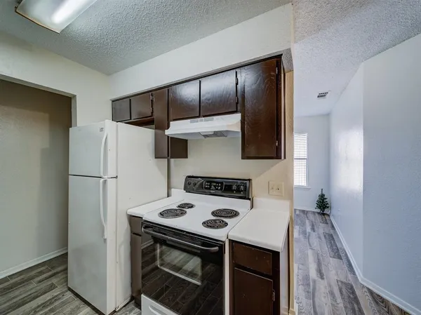 a kitchen with a refrigerator and a stove top oven