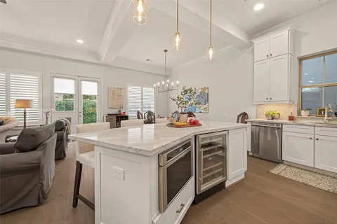 a kitchen that has a lot of white cabinets and wooden floor