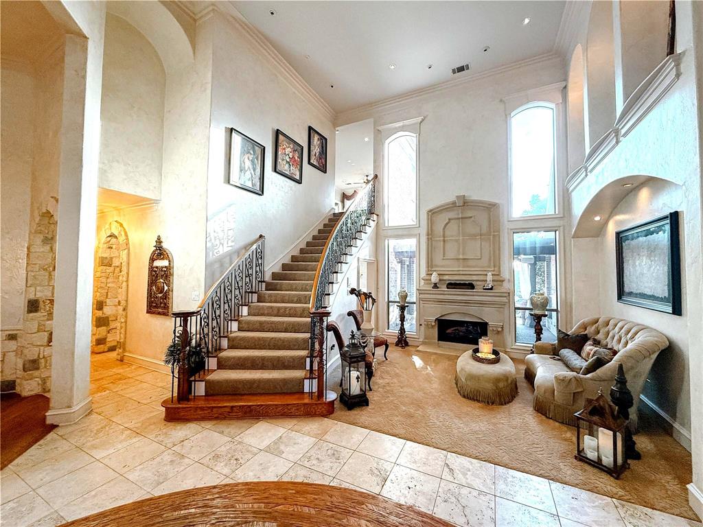 1919 Kings Pass Heath, TX 75032 - Photo 5 of 38 Grand entryway featuring high ceilings, a sweeping staircase with an ornate wrought iron railing, and large windows providing natural light