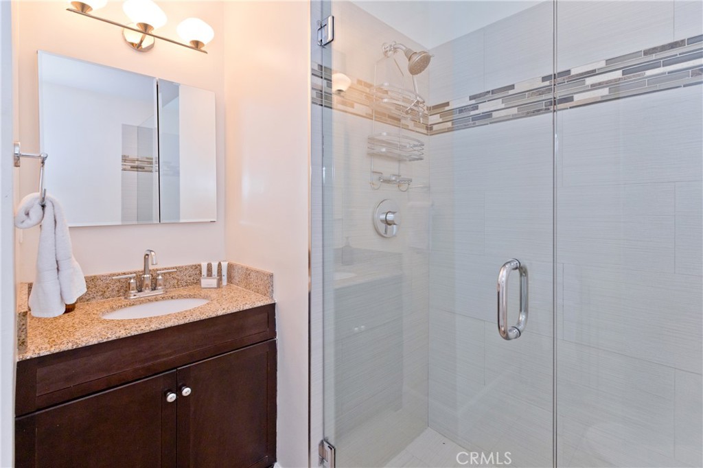 1057 East Marshall Way Palm Springs, CA 92262 - Photo 19 of 64 a bathroom with a shower sink vanity and mirror