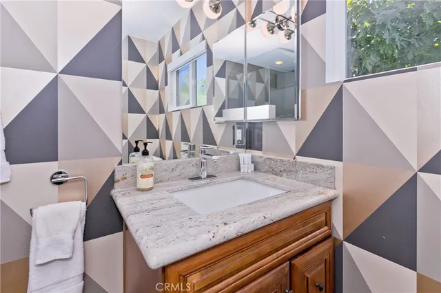 a bathroom with a granite countertop sink a toilet and a mirror