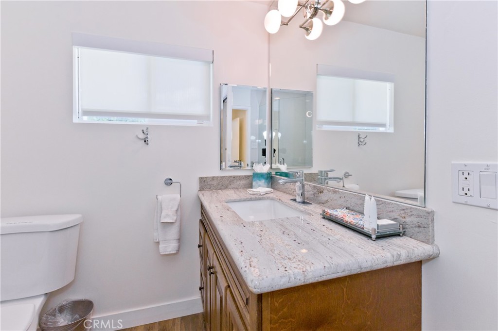 1057 East Marshall Way Palm Springs, CA 92262 - Photo 26 of 64 a bathroom with a granite countertop sink a toilet and a mirror