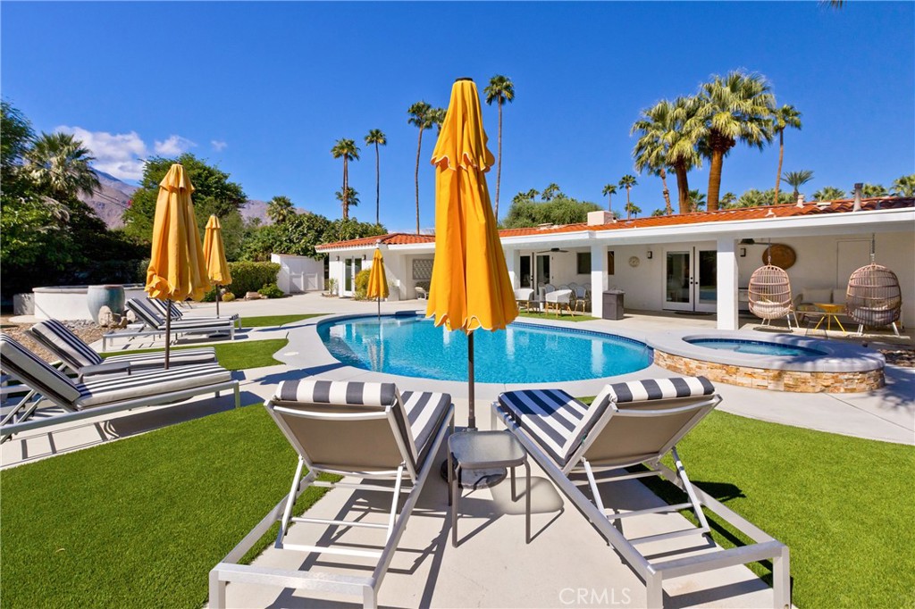 1057 East Marshall Way Palm Springs, CA 92262 - Photo 35 of 64 a view of a patio with table and chairs potted plants and palm tree