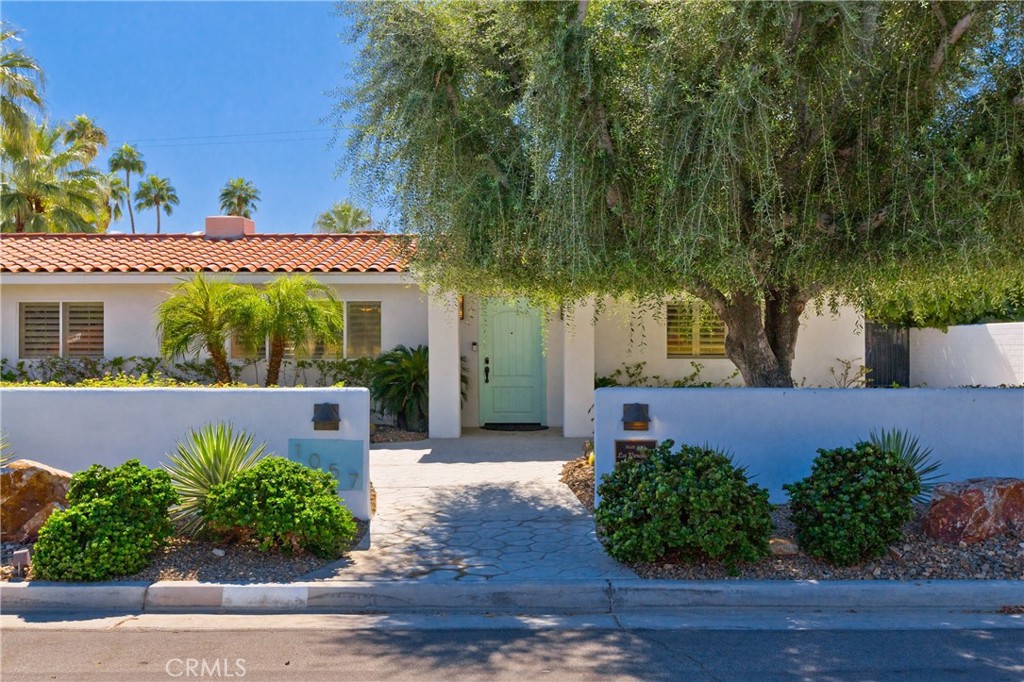 1057 East Marshall Way Palm Springs, CA 92262 - Photo 64 of 64 a sign that is sitting in front of a house with potted plants