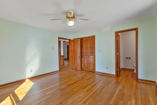 an empty room with wooden floor and closet