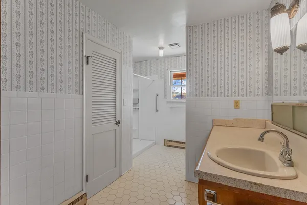 a bathroom with a sink a toilet and shower