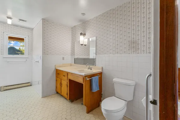 a bathroom with a stove a sink and a mirror